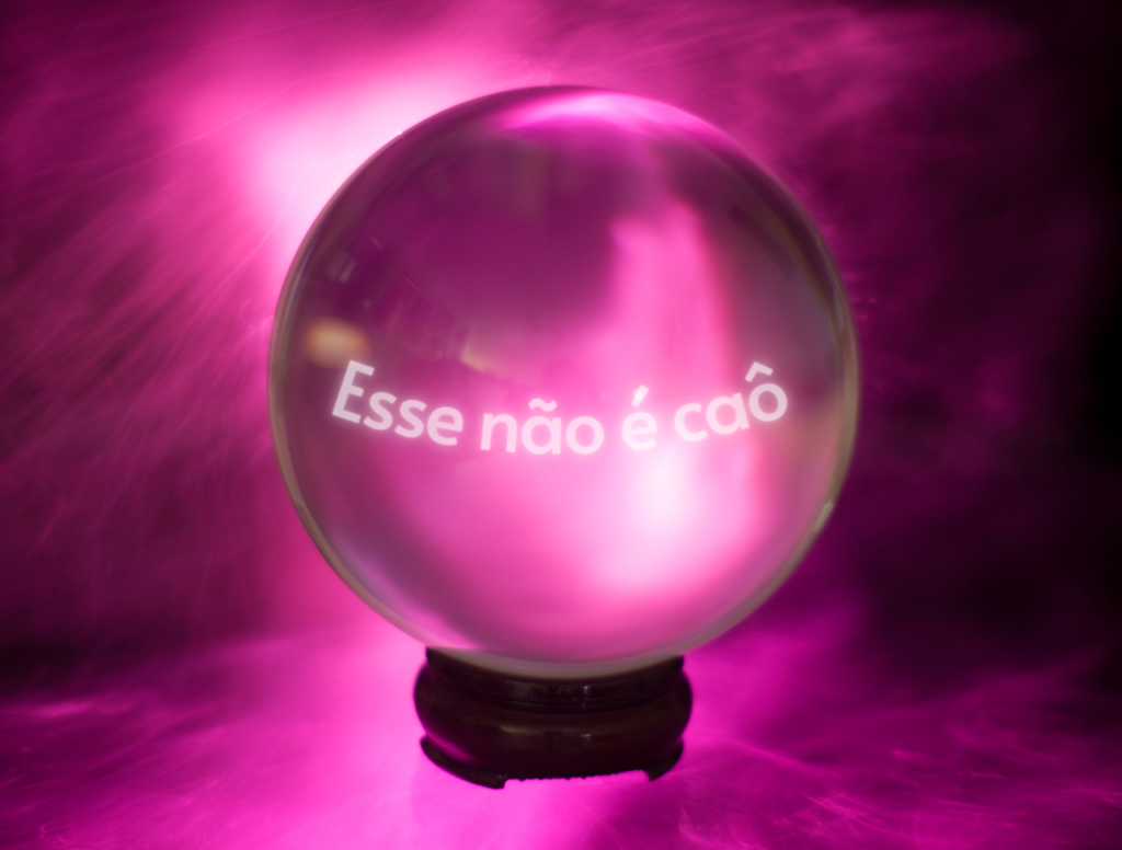 Bola de cristal com fundo rosa, e o texto "esse não é caô".