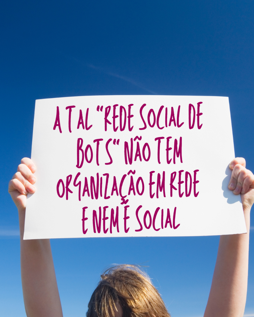 Pessoa segurando cartaz que diz "a tal 'rede social de bots' não tem organização em rede e nem é social'